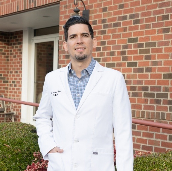 Doctor Ernesto Ulloa standing outside of Durham dental office