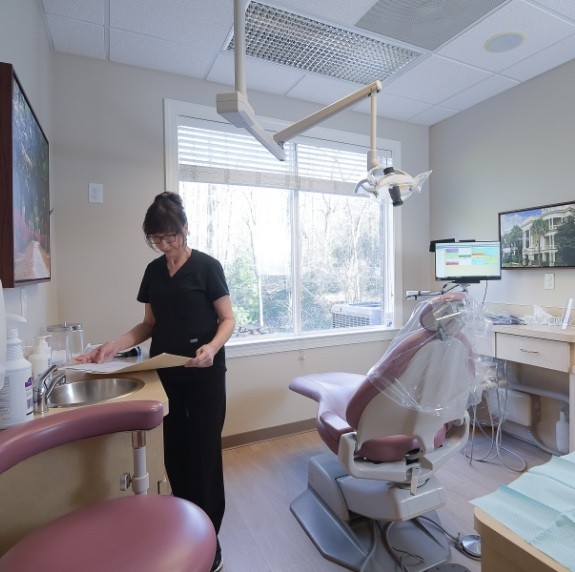 Dental team member looking at files in dental treatment room