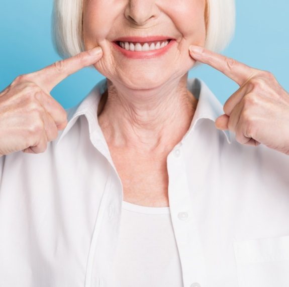 Senior woman pointing to her smile