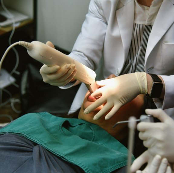 Dentist taking digital impressions of teeth