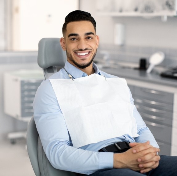 Smiling man sitting patiently in dental chair