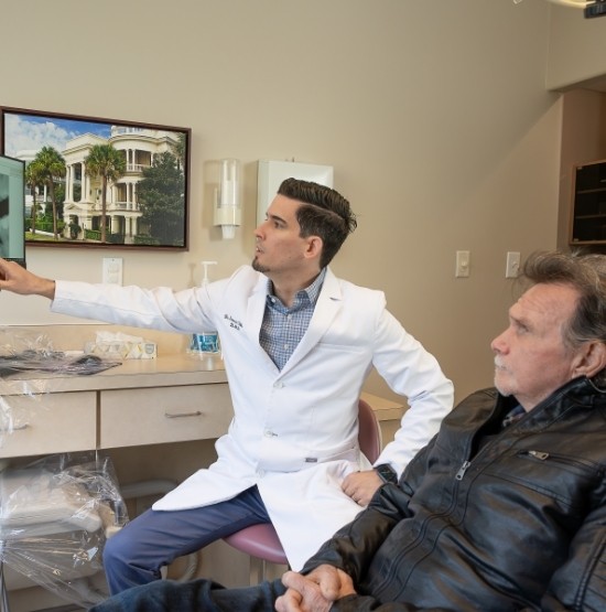 Doctor Ulloa showing a dental patient x rays of their teeth