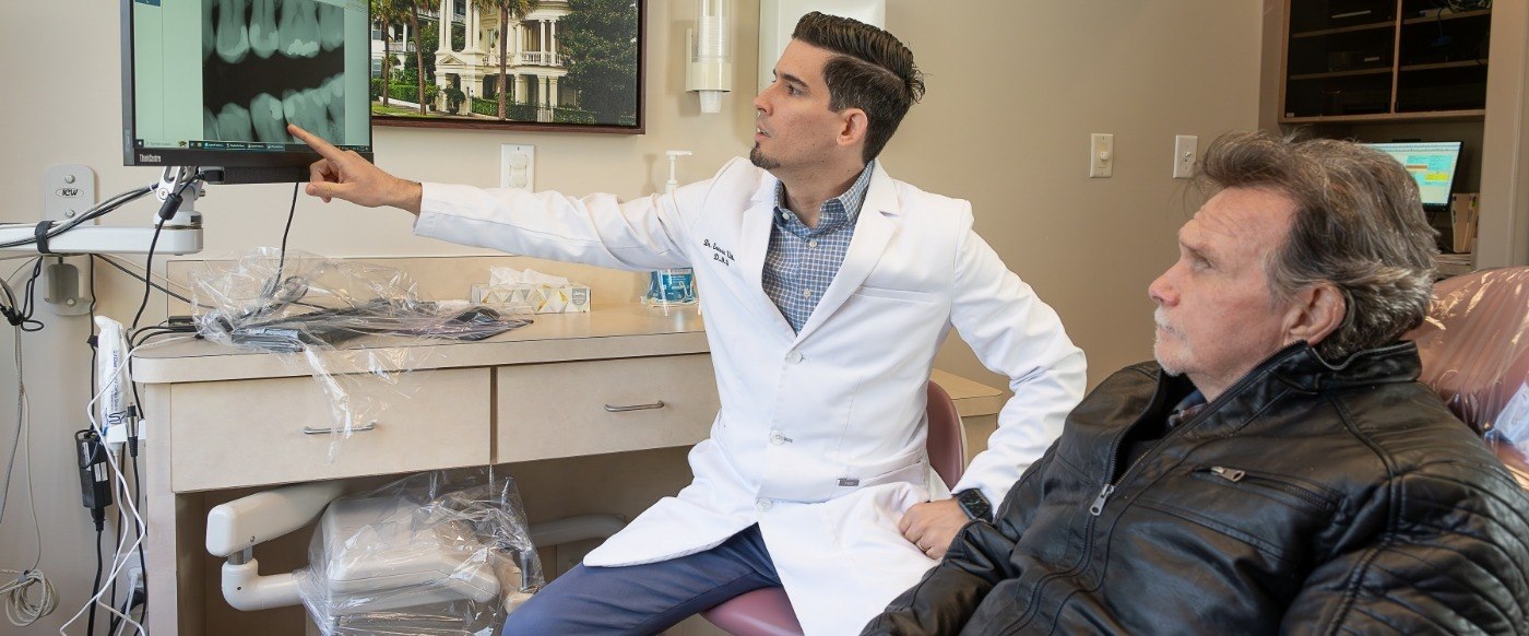 Durham North Carolina dentist Doctor Ernesto Ulloa showing a patient x rays of their teeth