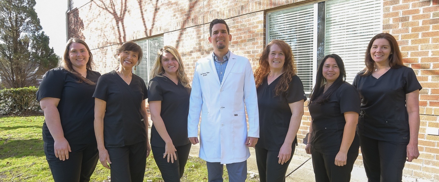 Smiling Durham dental team standing in front of Crafting Smiles