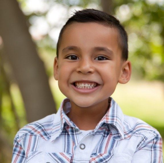 Young boy smiling outdoors