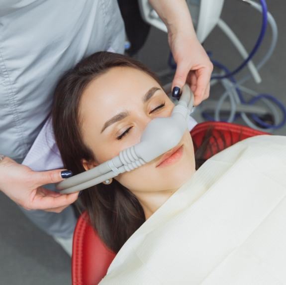 Relaxing dental patient with nitrous oxide mask over her nose